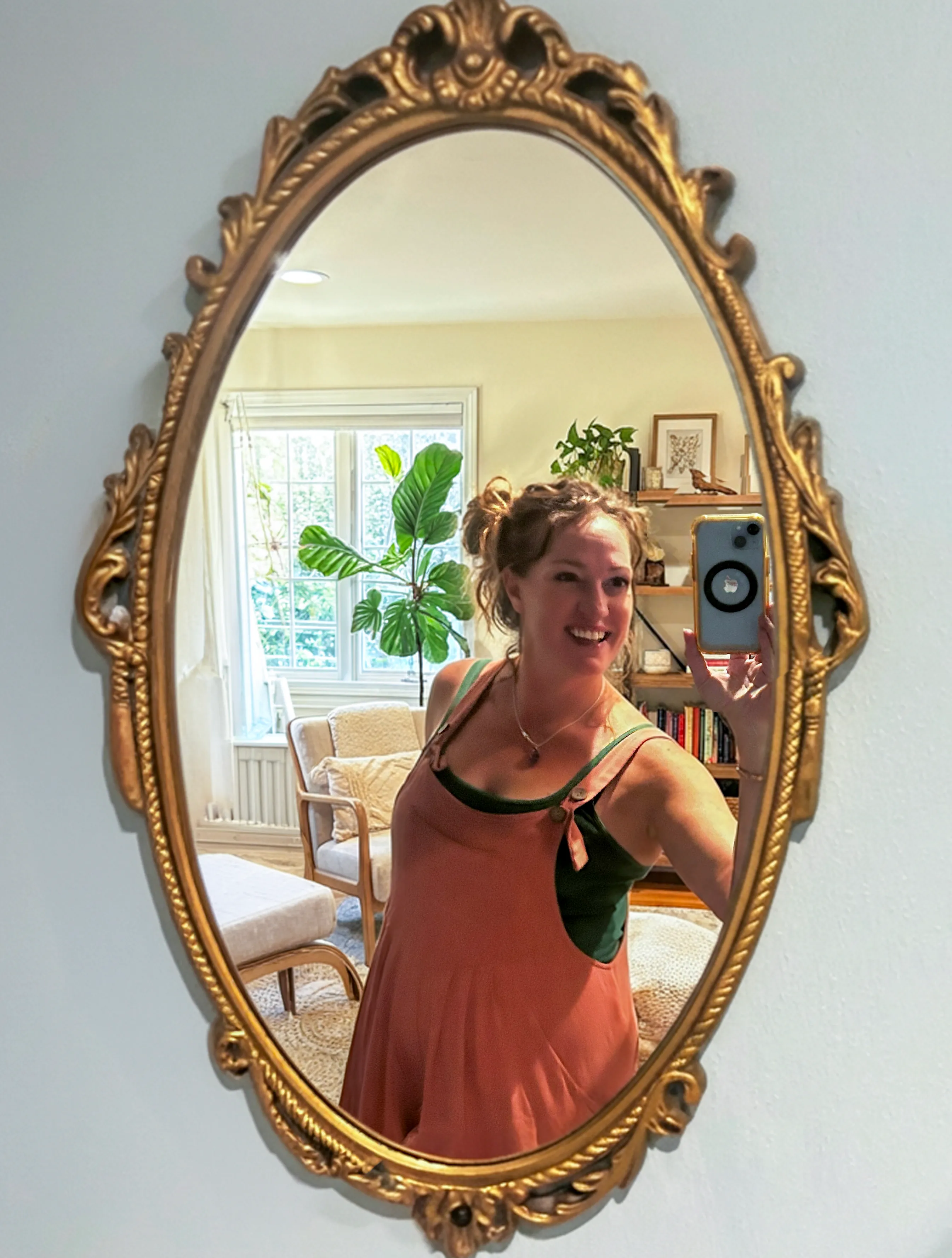 Jessica standing in a warm indoor space framed by plants.