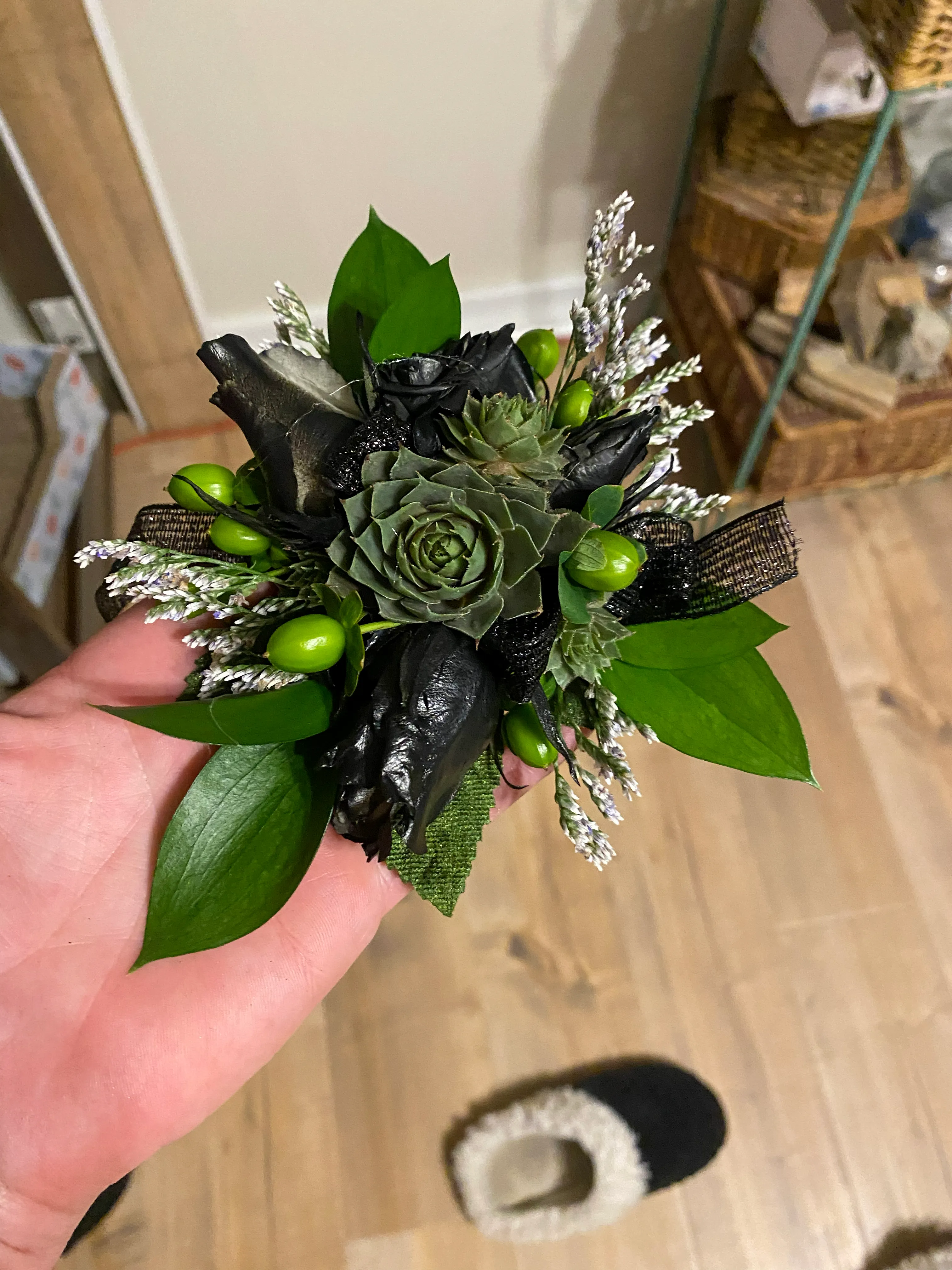 A finished succulent boutonniere crafted with greenery and floral detail.